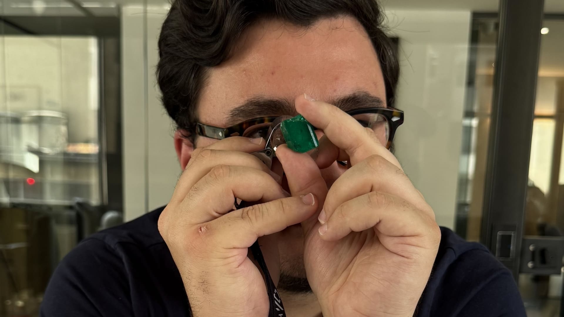 Guilhem Merolle analysant une émeraude colombienne dans son activité de sourcing